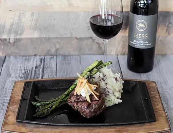 Plated grilled steak, mashed potatoes, asparagus, and Cabernet Sauvignon wine.