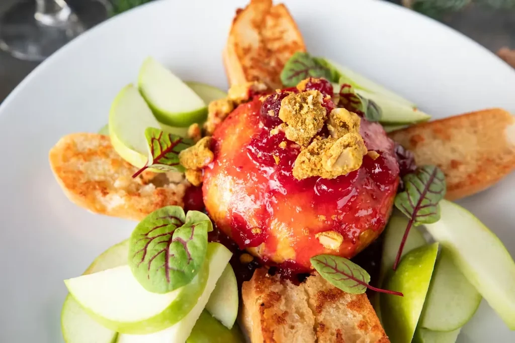 Baked apple with berry compote, nut crumble, green apple, crostini.
