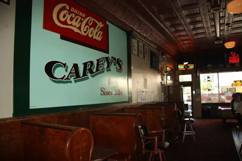 Carey's retro diner interior with dark wooden booths and vintage signs.
