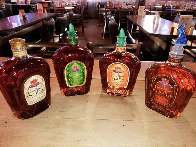 Crown Royal vanilla, apple, peach, maple whiskey bottles in a bar.