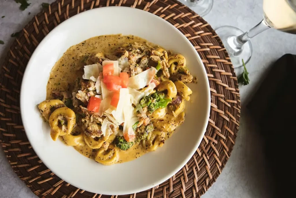 Overhead shot of creamy pasta with tomatoes, cheese, and broccoli.