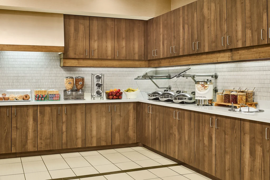 Hotel breakfast buffet with pastries, cereals, fruits, hot food, and beverages.