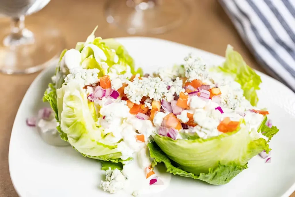 Wedge salad with blue cheese, tomatoes, onions, and creamy dressing.