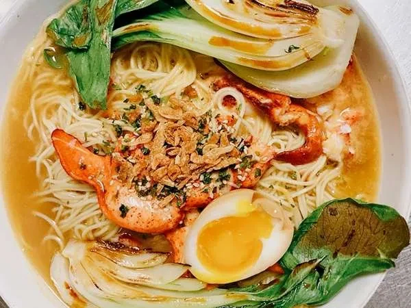 Noodle soup topped with lobster, soft egg, bok choy, crispy shallots.