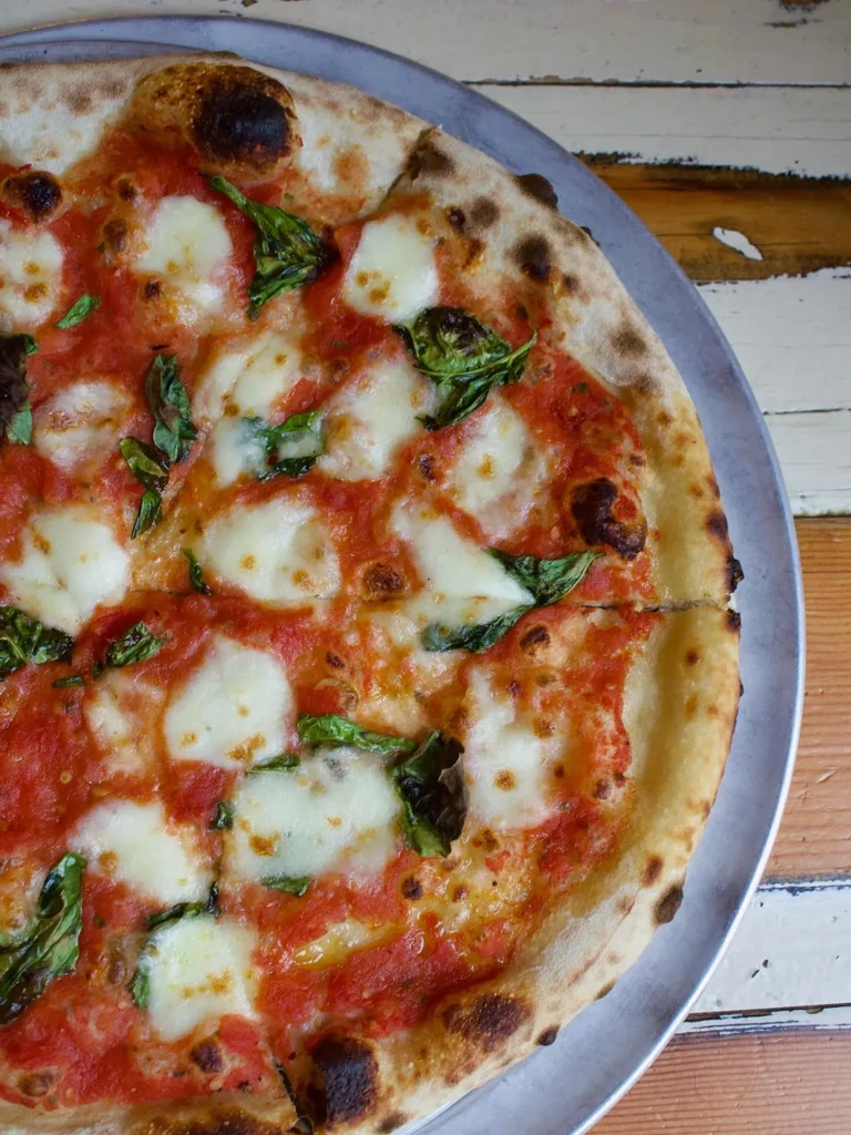 Freshly baked Neapolitan Margherita pizza with bubbly, charred crust.