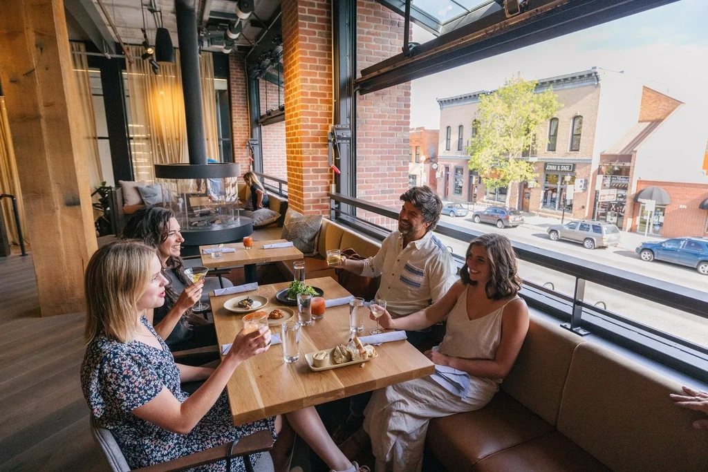 Group of four happily dining in a modern urban restaurant.