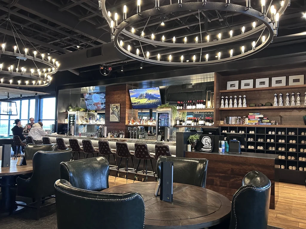 Modern industrial bar interior with a well-stocked bar and lounge seating.