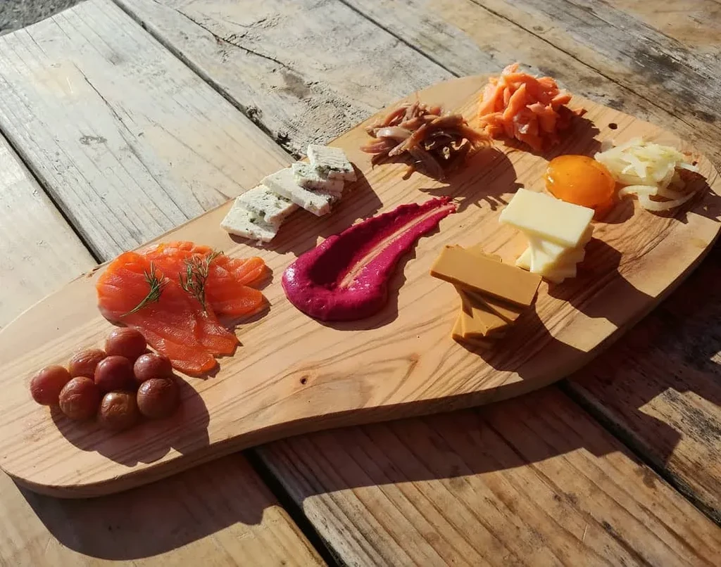 Colorful charcuterie and cheese platter on a rustic wooden board.