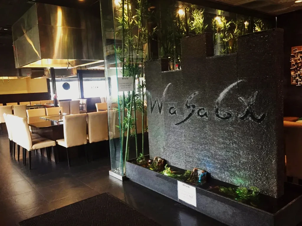 Modern Wasabi restaurant interior with water wall, bamboo, hibachi grills.