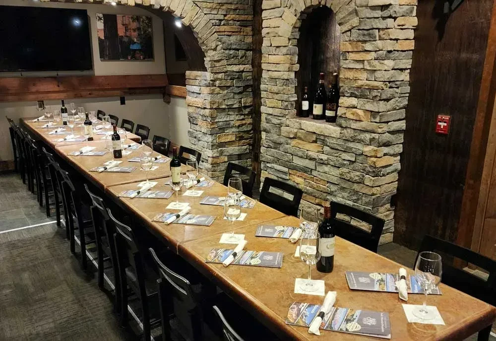 Long dining table set in a rustic stone private wine cellar.