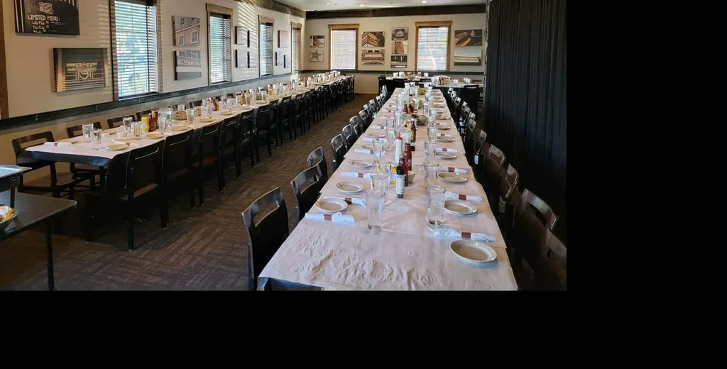 Clean restaurant dining room, long tables set for a large event.