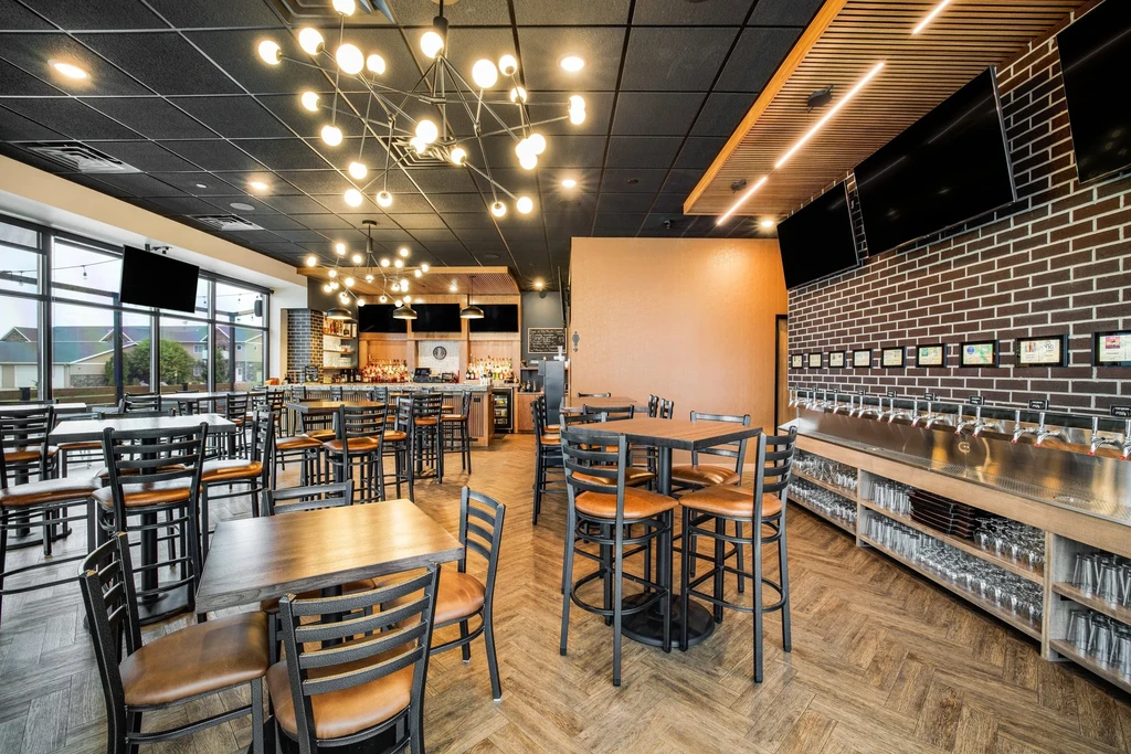 Empty, modern restaurant interior with a bar and self-pour tap wall.