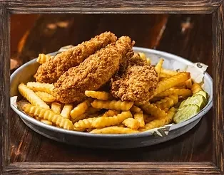Fried chicken, crinkle-cut fries, and pickles served in a rustic dish.