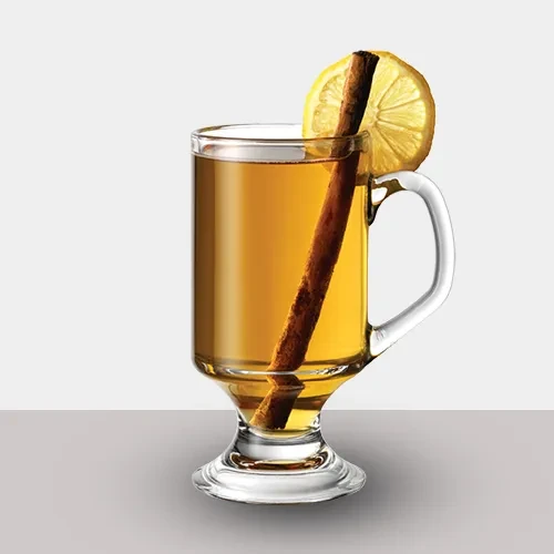 Glass mug with amber drink, cinnamon stick, and lemon slice.