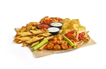 Appetizer platter with chicken, pizza, chips, vegetables, and three dipping sauces.