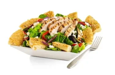 Grilled chicken salad with cheese, olives, red peppers, and pita chips.
