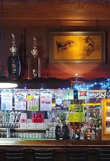 Rooters Bar Fargo: taps, liquor, specials, trophies, and blue string lights.