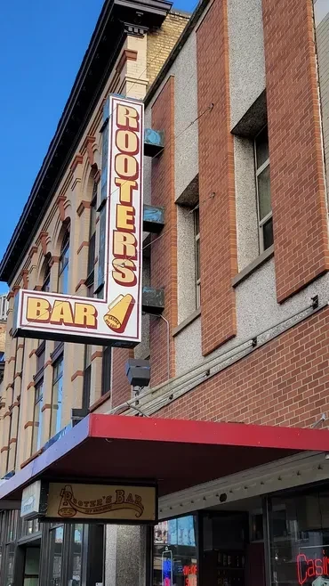 Rooters Bar exterior features two contrasting architectural styles and signs.