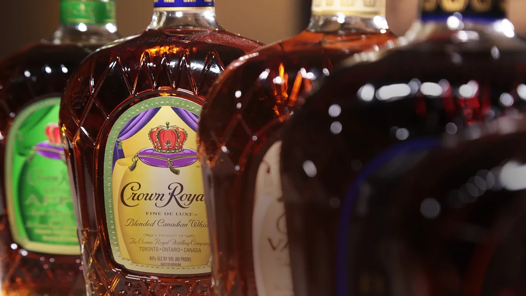 Several Crown Royal whiskey bottles in a row, purple and green labels.