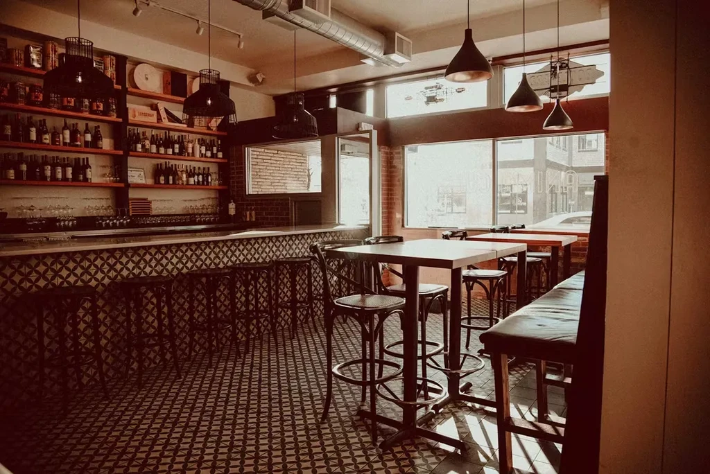 Modern restaurant and bar interior with patterned tiles and stocked bar.