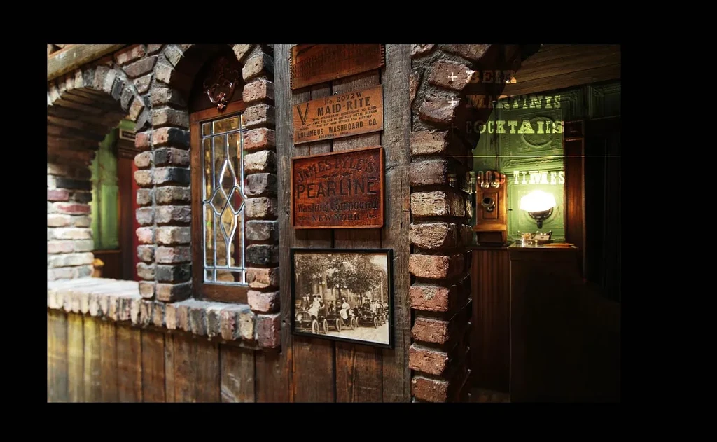 Rustic bar interior featuring brick archway, vintage signs, and green wall.