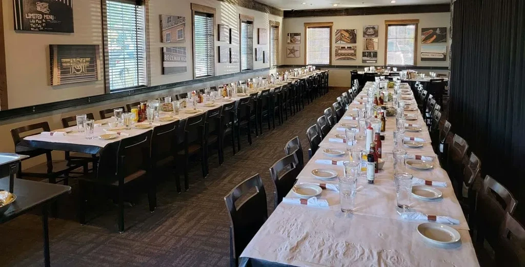 Empty banquet hall with long set tables and a 'LIMITED MENU' sign.