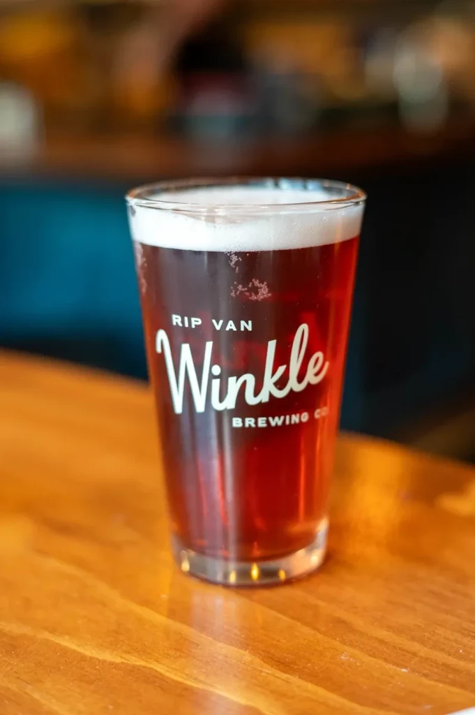 Pint glass of amber beer with RIP VAN Winkle BREWING CO logo.