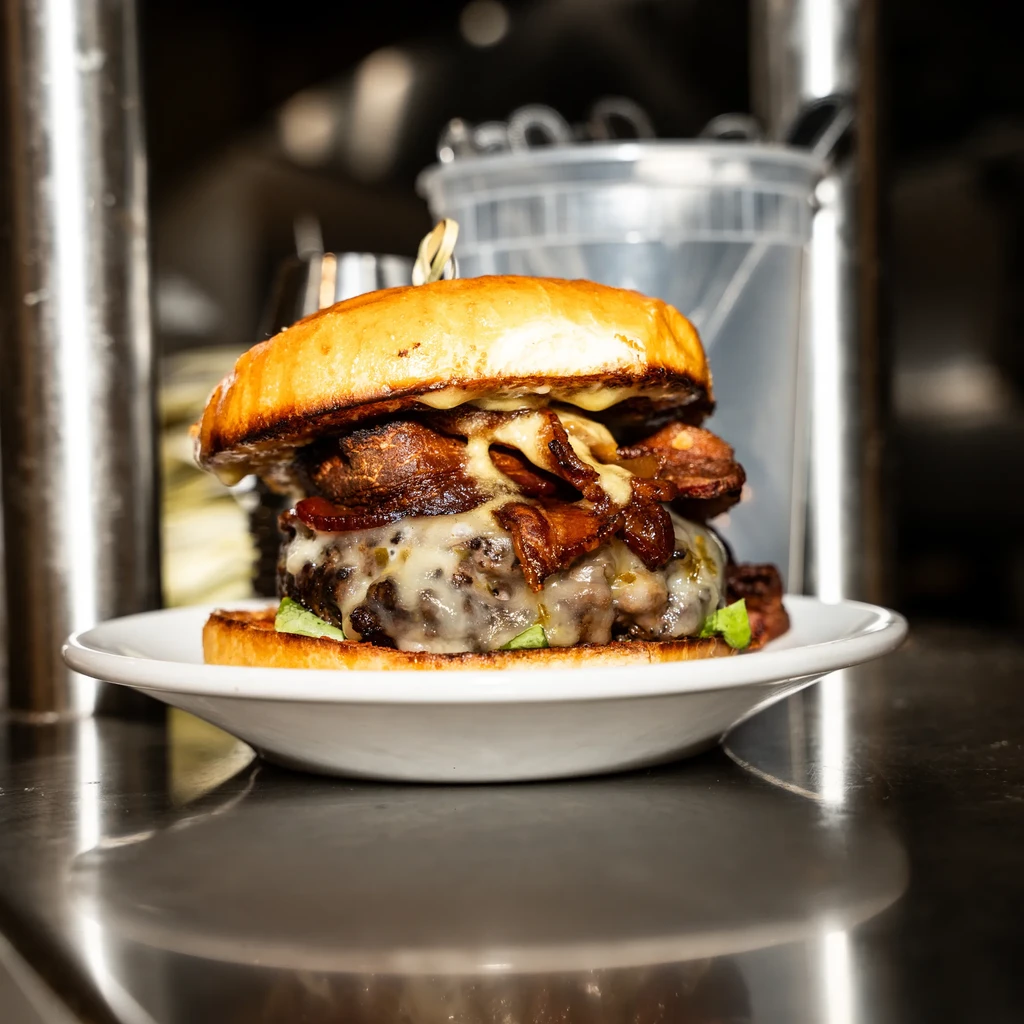 A close-up of a juicy hamburger with melted cheese and bacon.