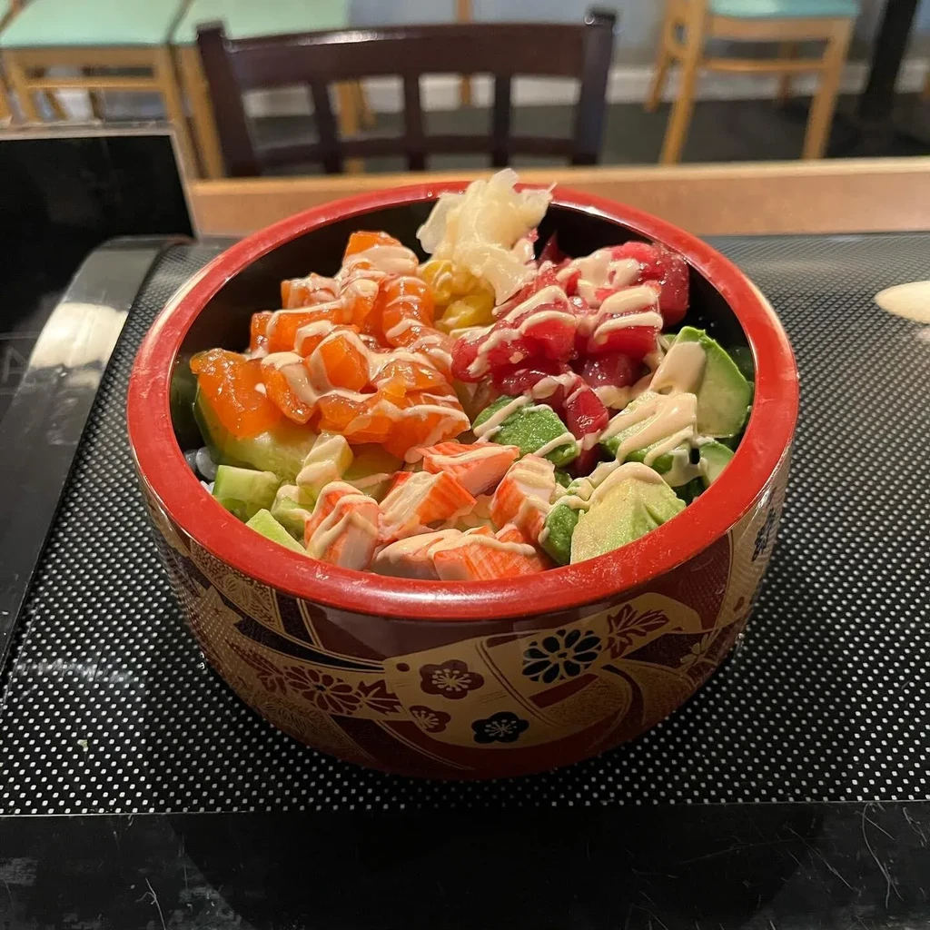 Vibrant poke bowl in a decorative bowl with salmon, tuna, and avocado.