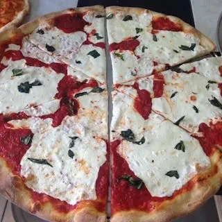 Sliced Margherita pizza with red sauce, melted mozzarella, and basil.