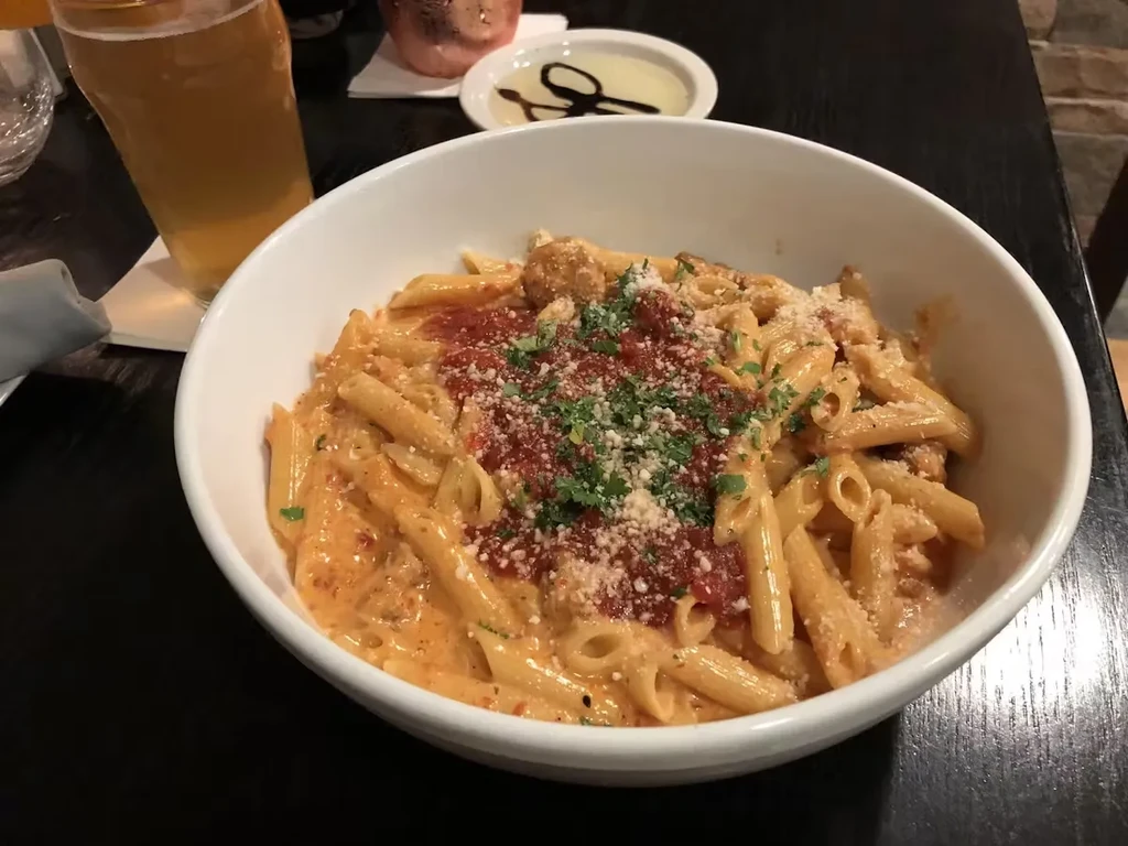 Pasta with red and cream sauces, topped with Parmesan and parsley.