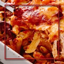 Close-up of baked ziti in a white dish, with a red border.