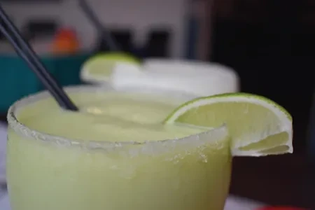 Two frosted lime margaritas with salt rims and straws.