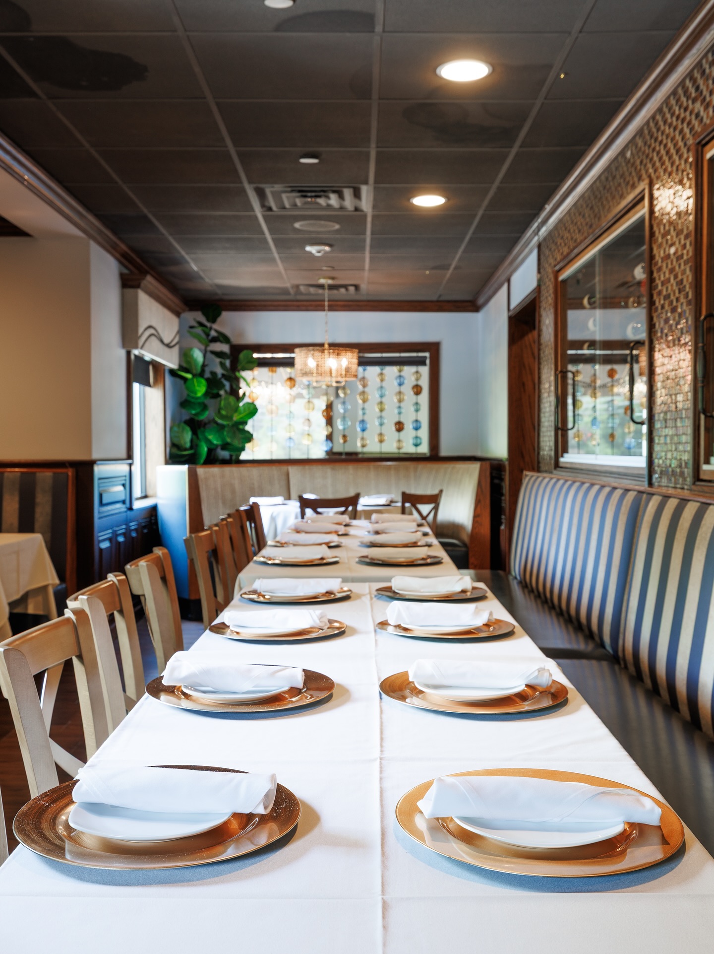 Long table set for dining in an empty restaurant.