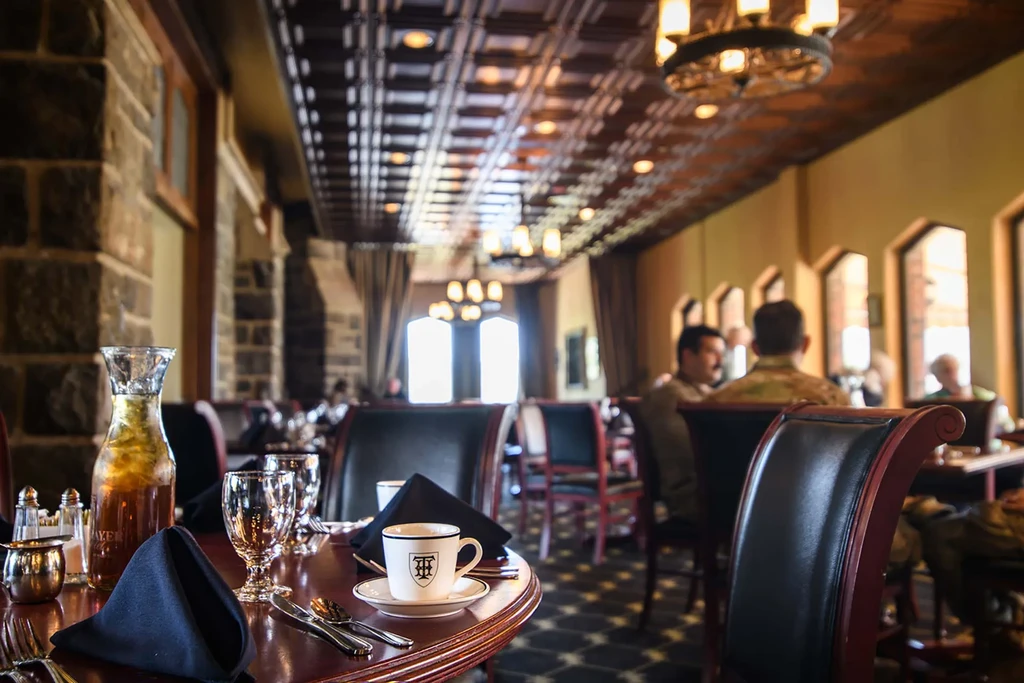 A set table in a restaurant with people dining in the background.