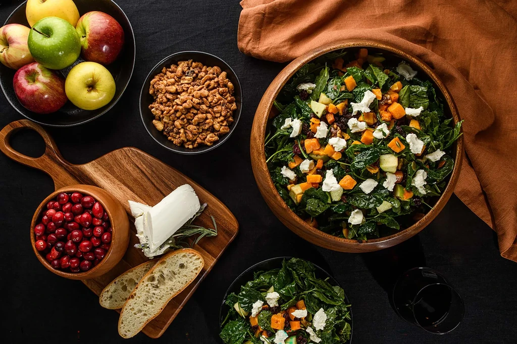 Autumnal table spread with butternut squash, kale, and goat cheese salad.