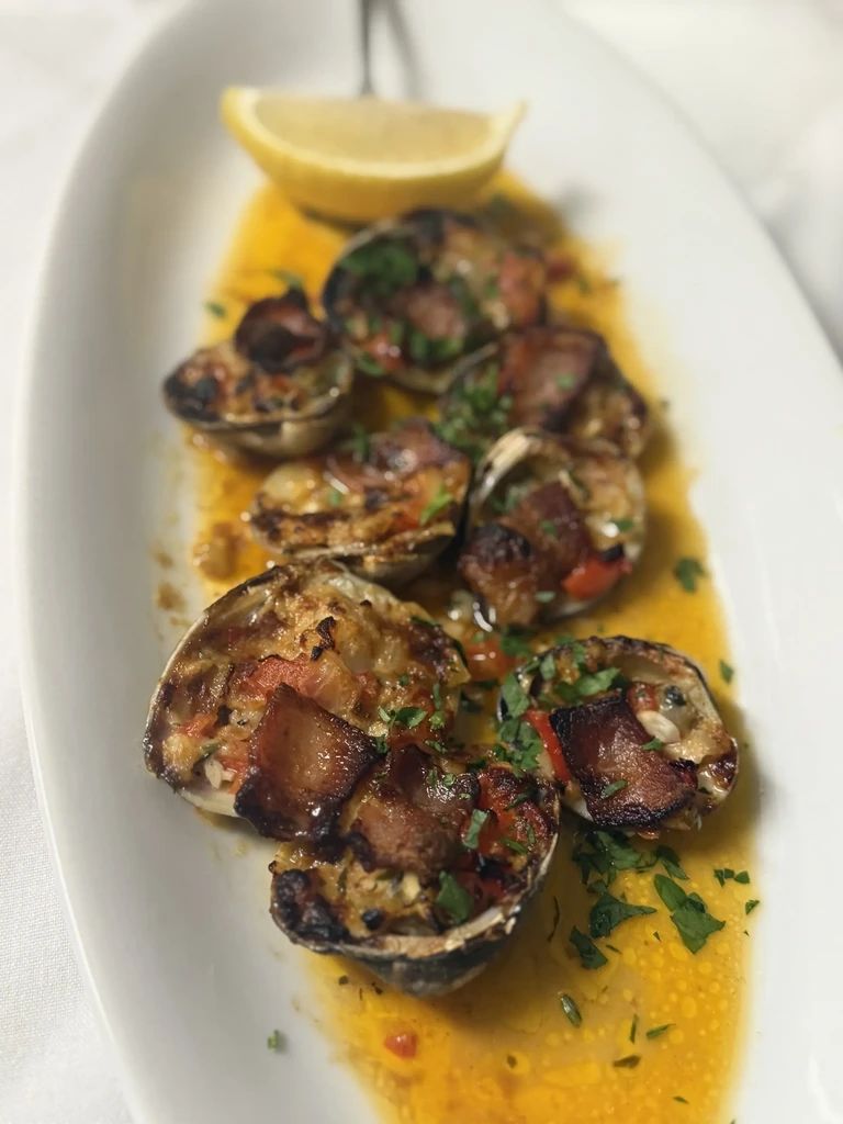 Baked clams or oysters topped with stuffing, bacon, and lemon.