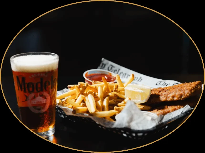 Fried fish and chips with lemon and a Modelo beer.