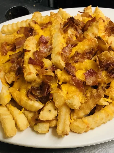 Golden crinkle-cut fries topped with melted cheese and crumbled bacon.
