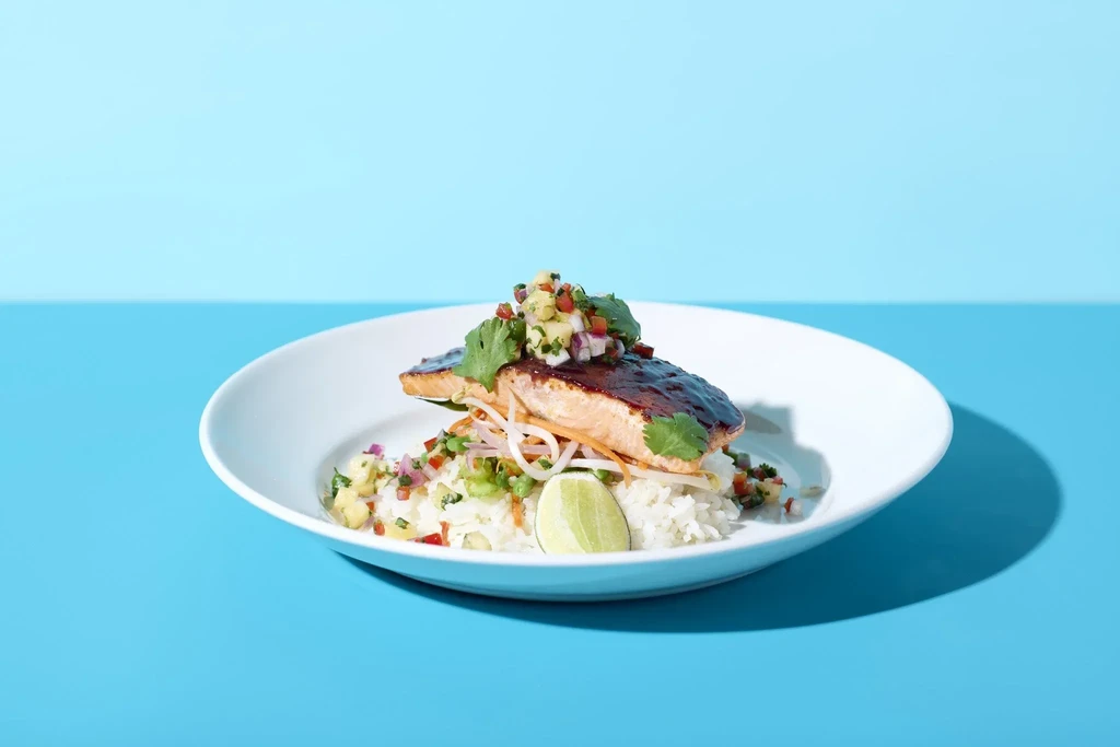 Glazed salmon on rice with fruit salsa, bean sprouts, and lime.