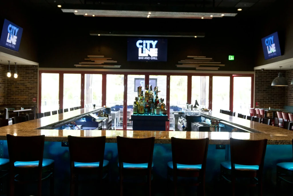 U-shaped bar counter in a modern, empty City Line Bar and Grill.