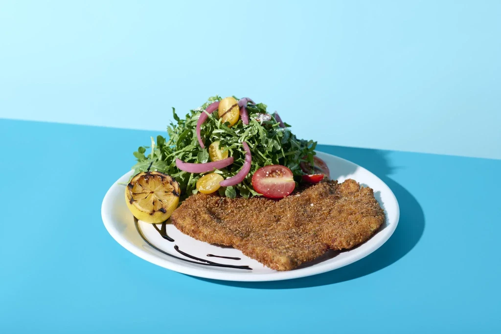 Breaded cutlet with arugula salad, grilled lemon, and balsamic drizzle.