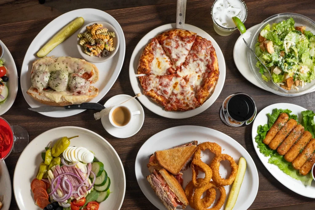Overhead view of a table filled with various restaurant food and drinks.