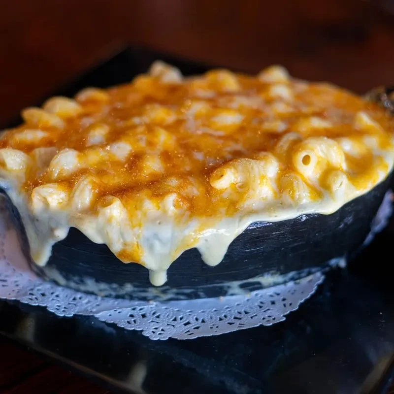 Bubbly, golden-brown macaroni and cheese in a cast-iron dish.