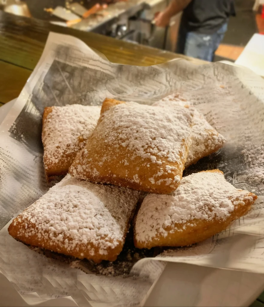 Five golden-brown rectangular pastries generously dusted with powdered sugar.