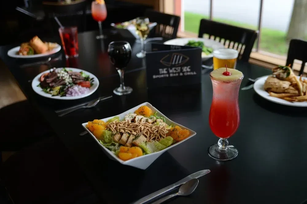 A table full of food and drinks at The West Side Sports Bar & Grill.