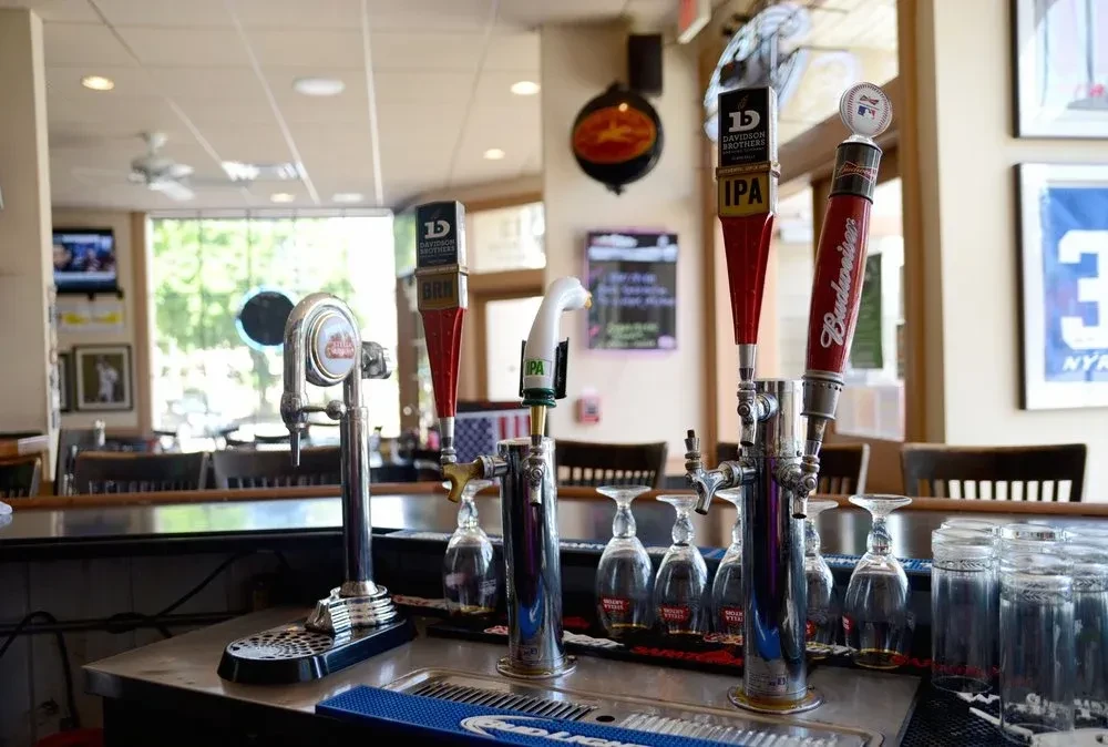 Bar counter with beer taps and clean glasses in a casual restaurant.