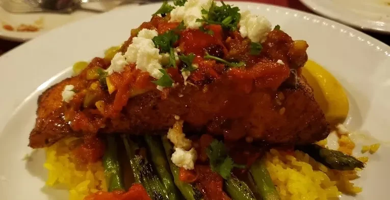 Golden-brown pan-seared fish, tomato salsa, feta, rice, asparagus, and lemon.