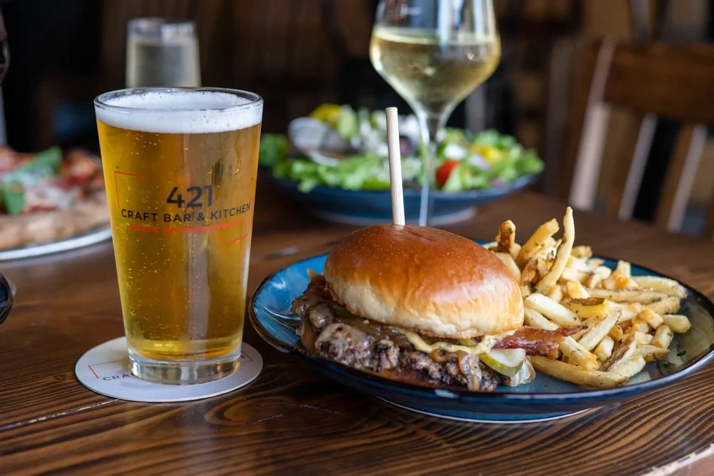 421 CRAFT BAR & KITCHEN beer, burger, fries on a wooden table.