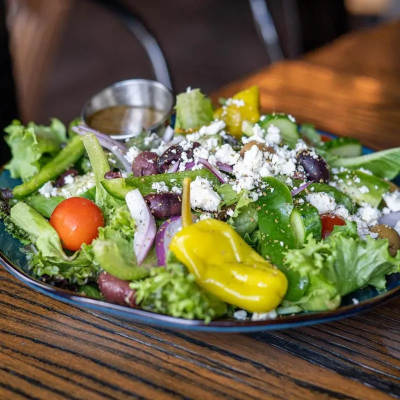 Vibrant Greek salad with feta, Kalamata olives, and pepperoncini.